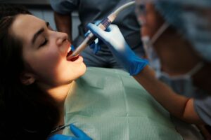 Close-up of a woman receiving dental treatment with modern equipment at a clinic.
